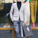 portrait-handsome-guy-holding-shopping-bags-hand-standing-front-window-display